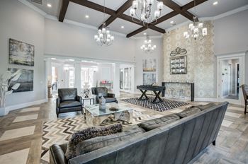A large, modern living room with a dark leather couch and a fireplace.